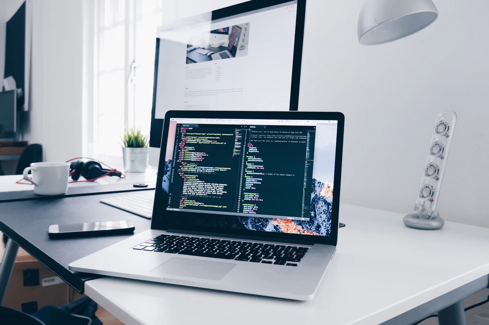 Web development code displayed on a laptop workspace